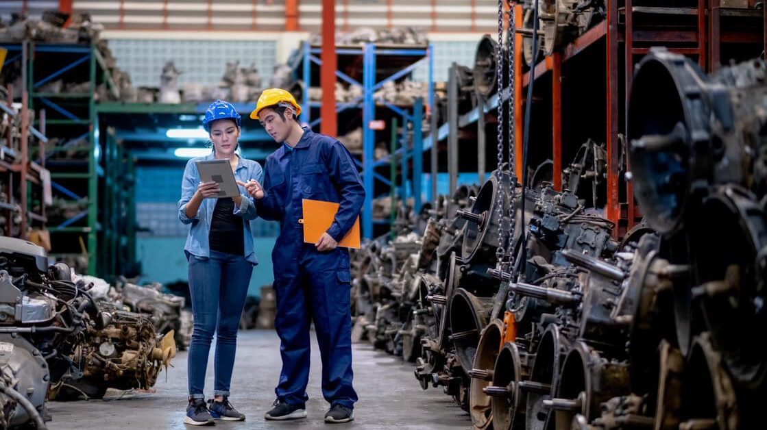 2 workers in a warehouse looking at a tablet