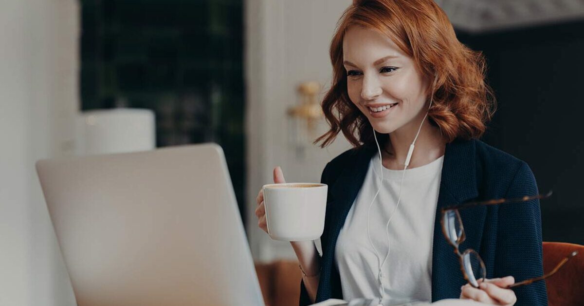 Girl working on laptop and coffee in hand