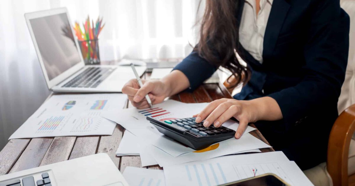 Businesswoman working finance with calculator in office.