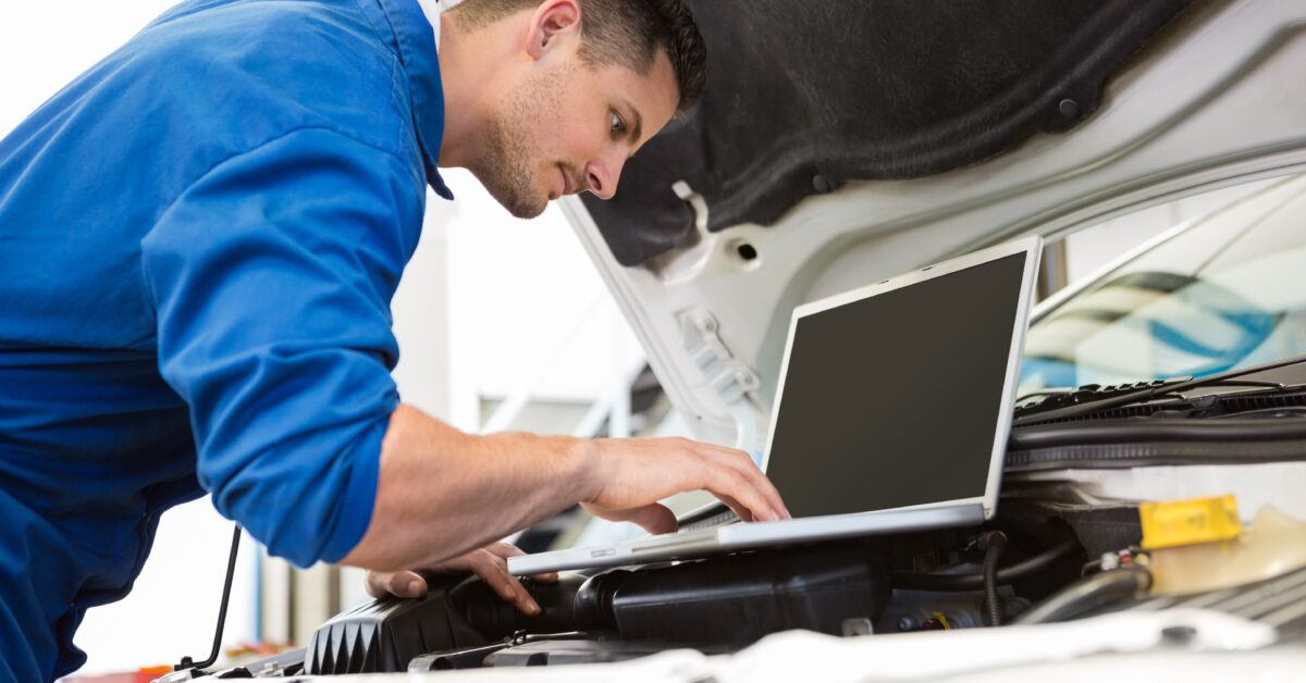 Mechanic using laptop on car